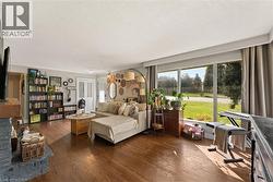 Hardwood flooring, expansive window, double French doors, built-in shelving, and a brick fireplace - 