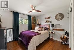 Hardwood-finish flooring, multiple windows, and a ceiling fan with integrated lighting - 