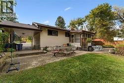 Expansive backyard featuring a manicured lawn, a large paver patio, an additional concrete patio, and a covered carport - 