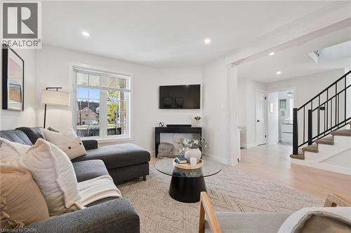 Recessed lighting, light wood-finish flooring, white walls, and a staircase with black metal railing - 6 Branwood Place, Kitchener, ON 