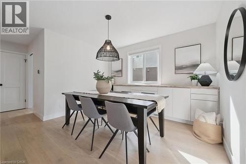 Light wood-finish flooring, white walls, modern pendant light fixture, white built-in cabinetry with light-toned countertops, and a window providing natural light - 6 Branwood Place, Kitchener, ON 