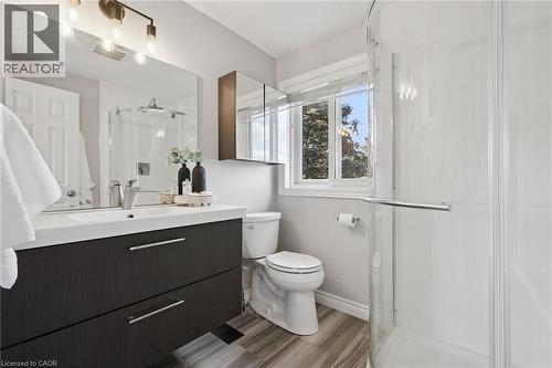 Modern vanity with integrated sink, tile flooring, and a glass-enclosed shower - 6 Branwood Place, Kitchener, ON 