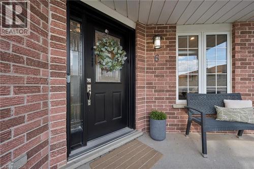 Brick exterior with a dark-paneled entry door, transom, and sidelight - 6 Branwood Place, Kitchener, ON 