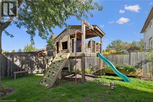 Backyard featuring a wooden playhouse with an attached slide, a climbing ramp, and a wooden fence - 6 Branwood Place, Kitchener, ON 