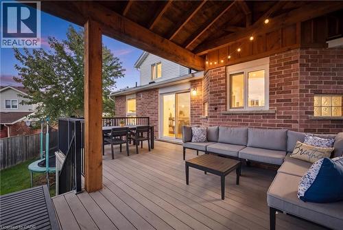 Covered outdoor deck with exposed wood beam ceiling, composite decking, and brick exterior wall - 6 Branwood Place, Kitchener, ON 
