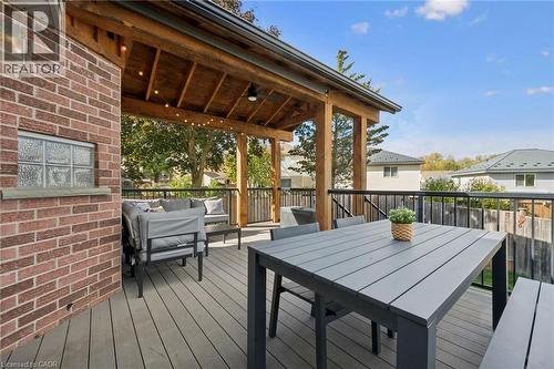 Expansive outdoor deck featuring wood-finish composite decking, a timber-framed covered patio, and a black metal railing system - 6 Branwood Place, Kitchener, ON 