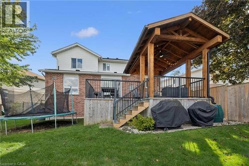 Expansive rear yard featuring a covered wooden deck, brick and siding exterior, and established perimeter fencing - 6 Branwood Place, Kitchener, ON 