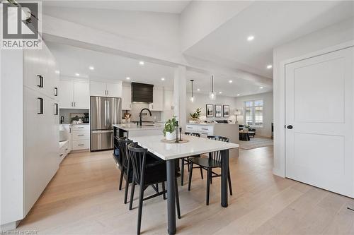 Spacious open-concept layout with light wood-finish flooring, white cabinetry, and stainless steel appliances - 6 Branwood Place, Kitchener, ON 