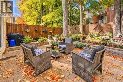 Paver patio area with a privacy fence and mature trees - 327 Oprington Place, Kitchener, ON 