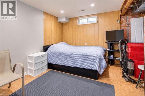 Wood-panel accent wall with a white painted wall, recessed lighting, and a single window - 327 Oprington Place, Kitchener, ON 