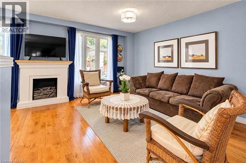 Hardwood flooring, fireplace, large picture windows, ceiling-mounted light fixture, and broad wall space - 327 Oprington Place, Kitchener, ON 