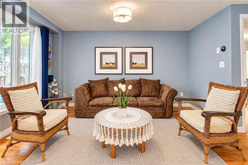 Hardwood-finish flooring, light blue wall paint, multiple windows, and a ceiling-mounted light fixture - 327 Oprington Place, Kitchener, ON 