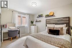 Neutral-toned interior featuring wall-to-wall carpeting, a wood-finish accent wall, ceiling-mounted light fixture, and large operable window - 
