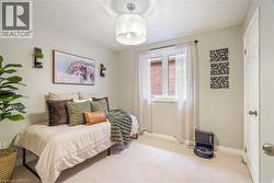 Neutral wall tones paired with neutral carpeting, an overhead drum light fixture, and a central window featuring hardware - 