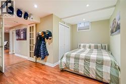 Wood-finish flooring, recessed ceiling lighting, a white louvered-door closet, and a multi-pane glass door - 