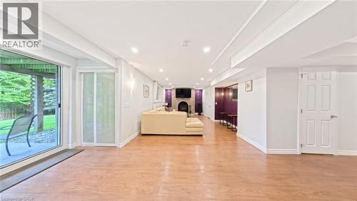 Open floor plan featuring recessed lighting, wood-finish flooring, sliding glass door, and a stone-surround fireplace - 488 Heather Hill Place, Waterloo, ON 
