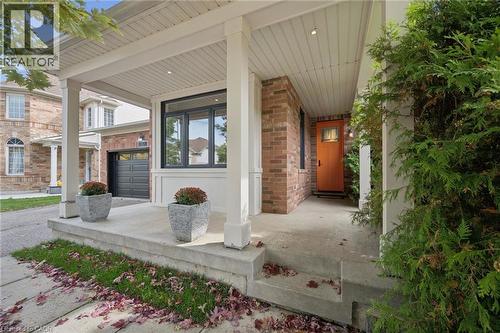 Covered front porch featuring a concrete foundation, brick veneer siding, recessed lighting, and a paneled entry door - 83 Glazebrook Crescent, Cambridge, ON 