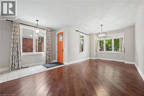 Wood-finish flooring, white ceramic tile entryway, multi-light hanging fixtures, and large picture windows - 83 Glazebrook Crescent, Cambridge, ON 