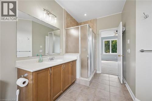 Bathroom vanity featuring a light-toned countertop, wood-finish cabinetry, and a full-width mirror - 83 Glazebrook Crescent, Cambridge, ON 
