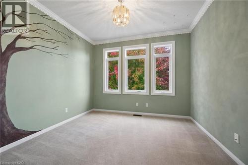 Room featuring three large windows, crown molding, wall-mounted decorative accent, and a metallic chandelier - 83 Glazebrook Crescent, Cambridge, ON 