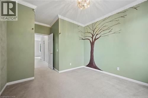 Room featuring crown molding, neutral carpeting, and a multi-tiered flush-mount light fixture - 83 Glazebrook Crescent, Cambridge, ON 
