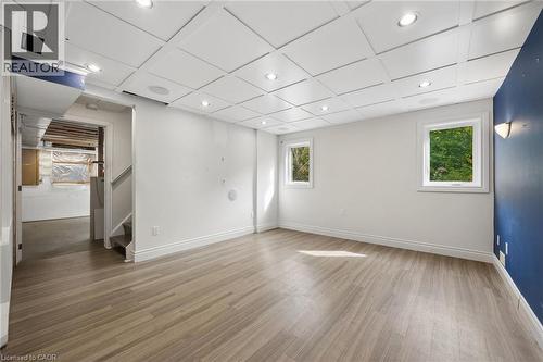 Interior room featuring coffered ceiling panels, recessed lighting, wood-finish flooring, and an accent wall - 83 Glazebrook Crescent, Cambridge, ON 