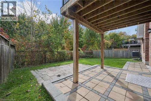 Covered patio featuring paver stonework, timber support posts, a fenced backyard, and a manicured lawn - 83 Glazebrook Crescent, Cambridge, ON 