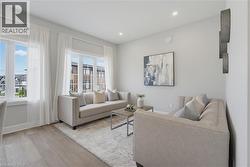 Neutral tone living space featuring wood-finish flooring, recessed lighting, and large multi-pane windows - 
