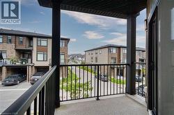 Covered balcony featuring black metal railings and concrete flooring - 
