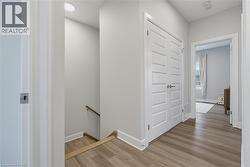 Neutral paint palette, wood-finish flooring, white paneled double doors, and flush-mount lighting - 