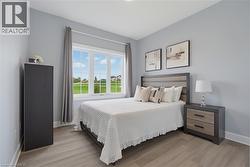 Neutral-toned walls paired with light wood-finish flooring and a multi-pane window featuring exterior green space - 