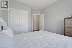 Interior room featuring neutral-toned walls, double-panel closet doors, and five-panel shaker-style interior doors with brushed nickel hardware - 
