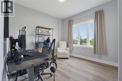 Neutral-toned interior space featuring wood-finish flooring and a multi-pane window with natural light - 