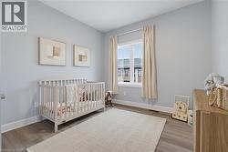 Neutral-toned walls, wood-finish flooring, and a large window with a white mullion frame - 