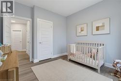 Neutral-toned interior featuring wood-finish flooring, light grey walls, and multi-panel interior doors - 