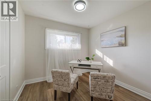 Neutral interior featuring wood-finish flooring, a horizontal window, and a contemporary flush-mount ceiling light fixture - 46 Traynor Avenue, Kitchener, ON 