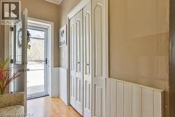 Wood-finish flooring with white wainscoting and bi-fold closet doors - 
