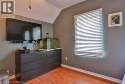 Vaulted ceiling with a ceiling fan, a window with horizontal blinds, and wood-finish flooring - 
