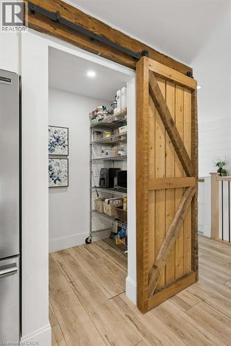 Pantry featuring a wood-plank barn door with black iron hardware and wood-finish flooring - 361 Lee Circle, Waterloo, ON 
