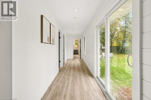 Hallway featuring shiplap wall paneling, wood-finish flooring, recessed lighting, and a full-length sliding glass door - 361 Lee Circle, Waterloo, ON 