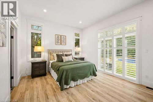 Wood-finish flooring, recessed lighting, and white plantation shutters framing a multi-panel glass door - 361 Lee Circle, Waterloo, ON 