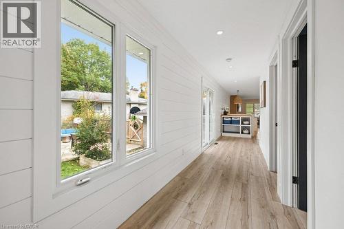 Hallway featuring horizontal shiplap wall paneling, wood-finish flooring, large double-pane windows, and recessed lighting - 361 Lee Circle, Waterloo, ON 