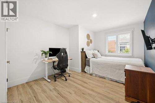 Wood-finish flooring, recessed lighting, and white plantation shutters - 361 Lee Circle, Waterloo, ON 