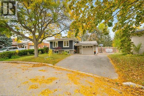 Single-story exterior featuring horizontal siding, brick masonry, an attached garage, and a paved driveway - 361 Lee Circle, Waterloo, ON 
