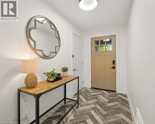 Entryway featuring herringbone-patterned flooring, solid door with glass pane detail, and modern flush-mount lighting - 361 Lee Circle, Waterloo, ON 