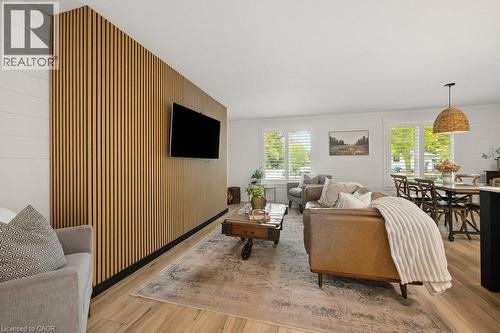 Vertical wood-slat accent wall, horizontal plank wall detailing, wood-finish flooring, and white shutter window treatments - 361 Lee Circle, Waterloo, ON 