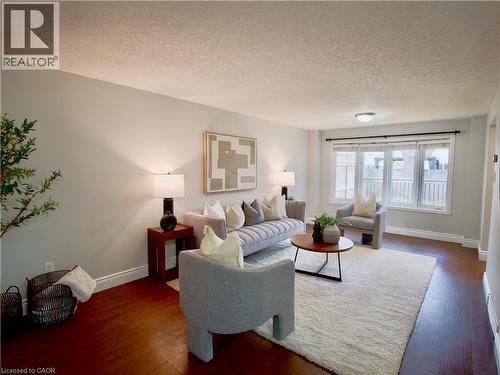Living area featuring wood-finish flooring, a neutral color palette, and a multi-panel window configuration - 449 Exmoor Street, Waterloo, ON 
