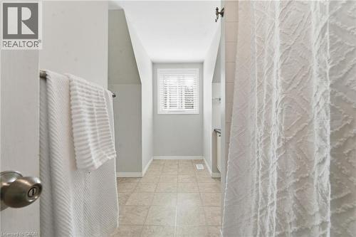 Neutral-toned interior featuring ceramic tile flooring, a window with horizontal blinds, and angled wall architecture - 449 Exmoor Street, Waterloo, ON 