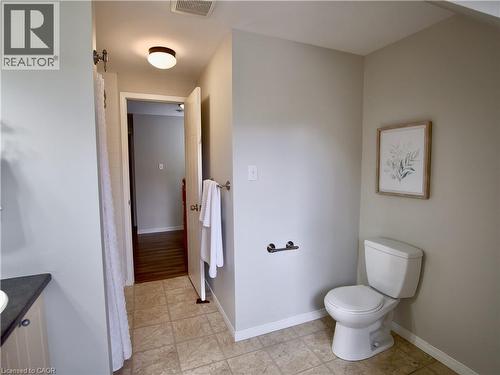 Bathroom featuring tile flooring, a two-piece toilet, a dark-toned vanity countertop, and a ceiling-mounted flush light fixture - 449 Exmoor Street, Waterloo, ON 