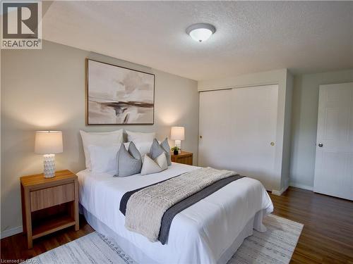 Neutral-toned interior featuring wood-finish flooring, sliding closet doors, and a ceiling-mounted light fixture - 449 Exmoor Street, Waterloo, ON 